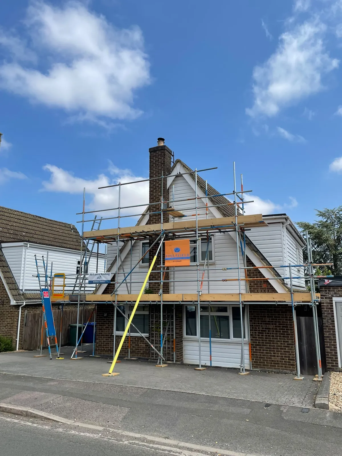 Full front elevation scaffold on a chalet-style house with an Englefield banner