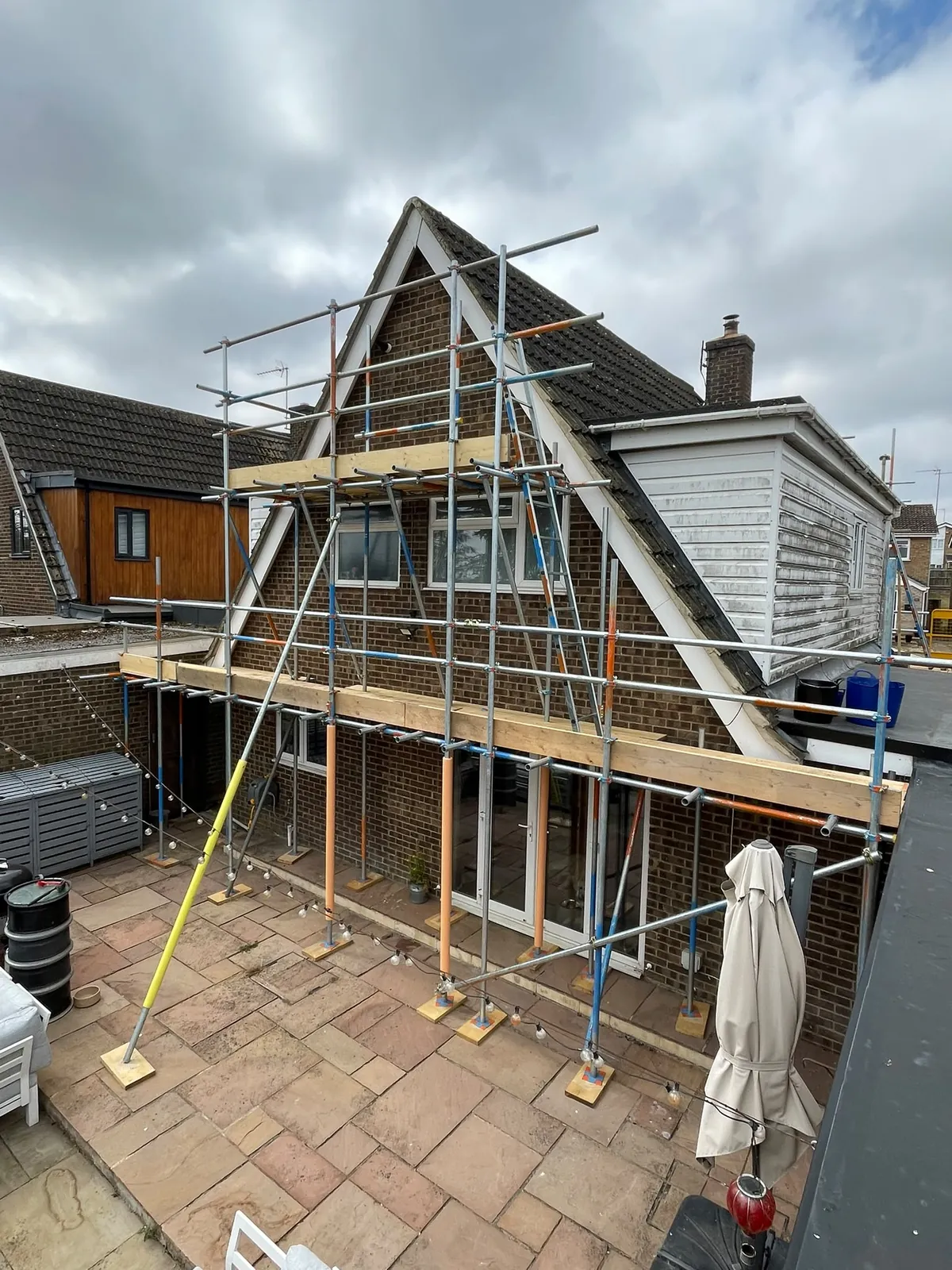 Scaffold erected to the rear gable of a house, viewed from roof level