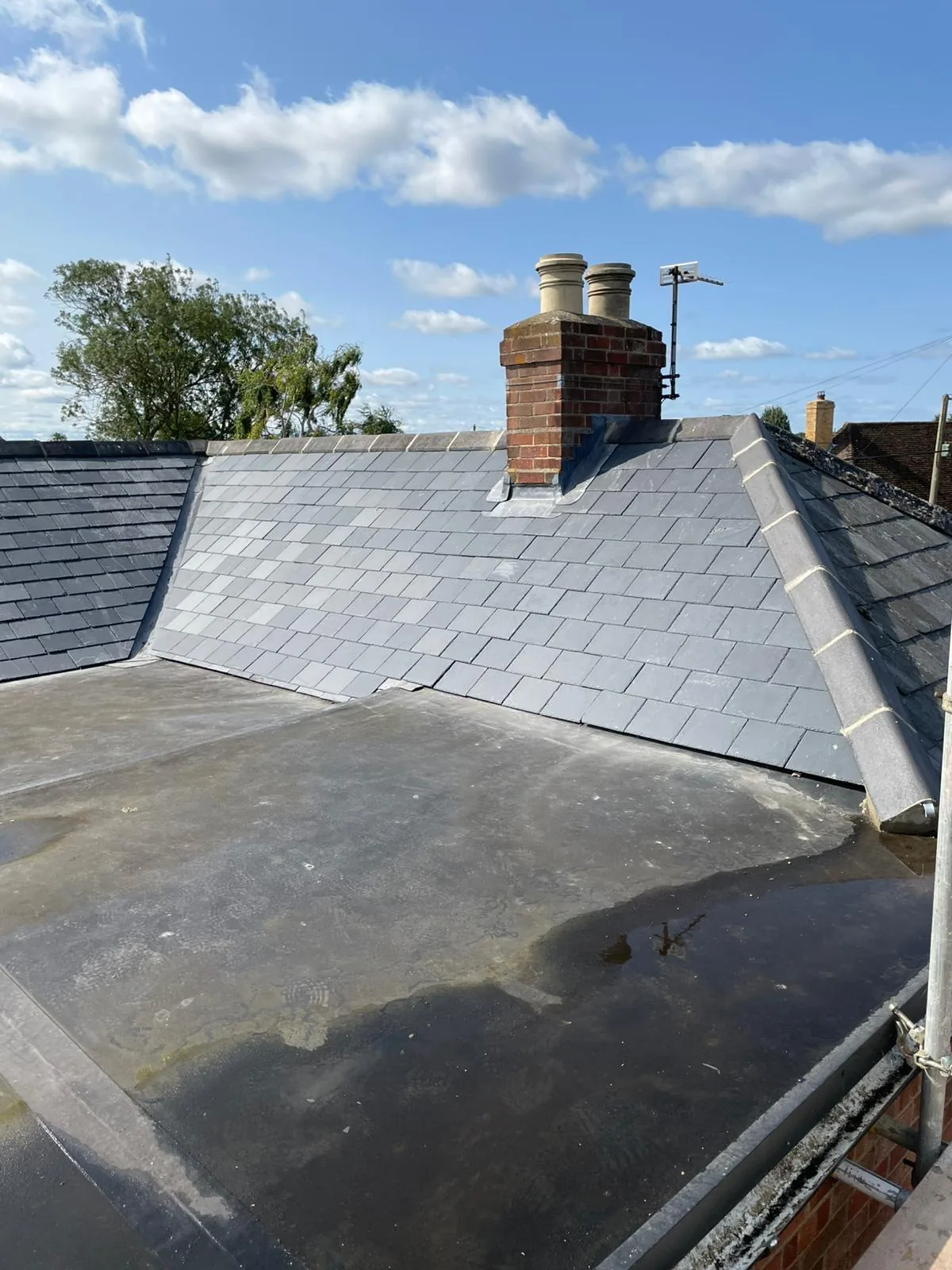 Completed natural slate roof with twin chimneys by Englefield Scaffolding and Roofing Limited